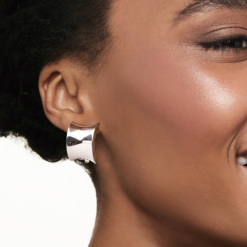 Sterling silver concave half-hoop clip-on earrings on ear, polished shine