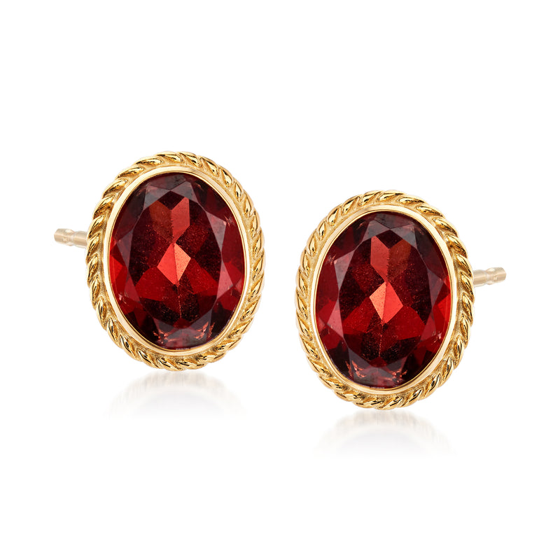 Oval garnet stud earrings in 14kt yellow gold with ornate round halo bezel