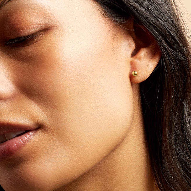 14kt yellow gold 4mm ball stud earrings on ear, close-up side view