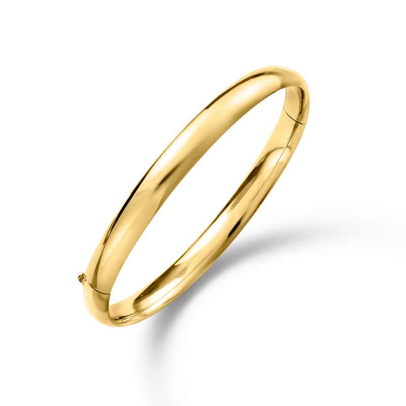 Polished yellow gold bangle bracelet, angled view of smooth cuff hoop and clasp ends