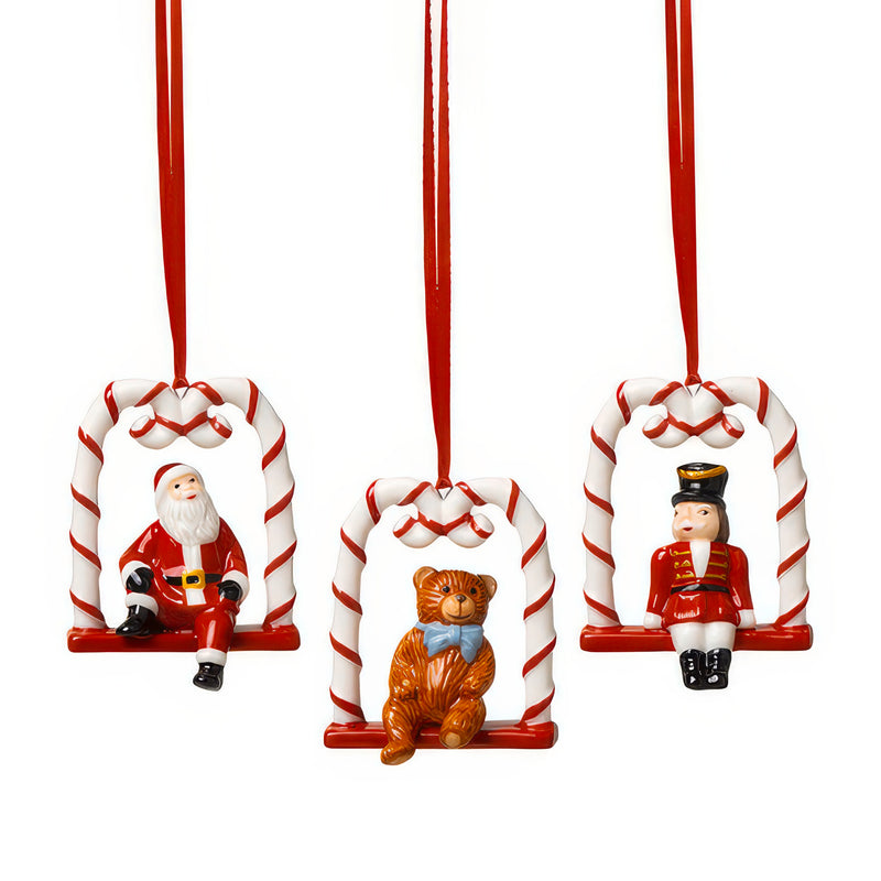 Porcelain candy cane swing set, three holiday character ornaments on red-and-white stripes
