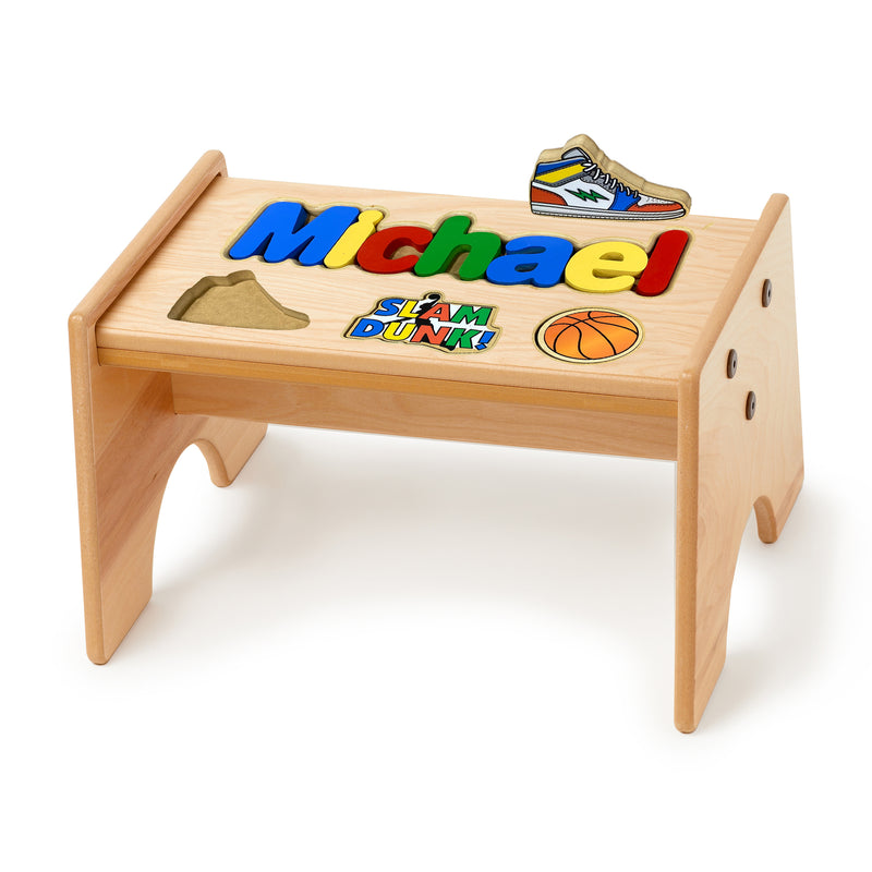 Maple-finished wooden puzzle stool with basketball-themed name decal and cutout sides