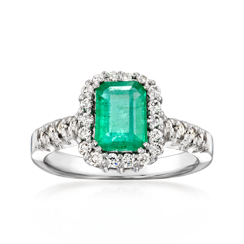Emerald-cut emerald green center stone haloed by diamonds on 14kt white gold ring