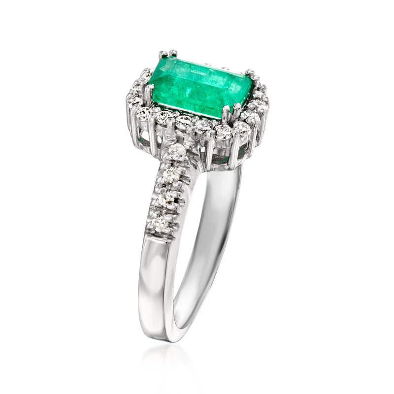 Emerald green rectangular center stone with diamond side clusters on 14kt white gold band