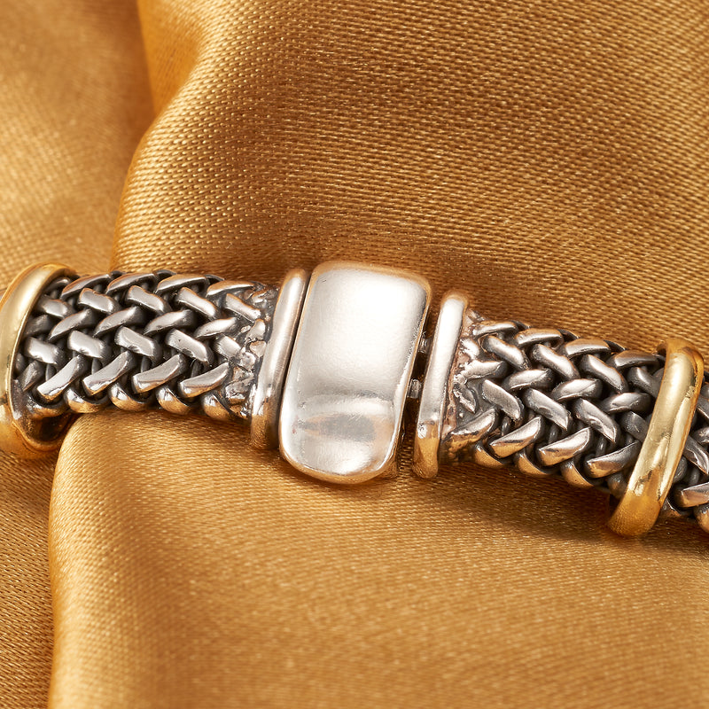Close-up of woven bracelet with square silver clasp and small gold trim rings