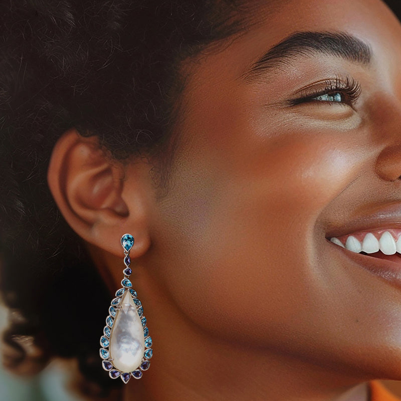 Sterling silver drop earrings on model: mother-of-pearl teardrop, blue stones and iolite accents