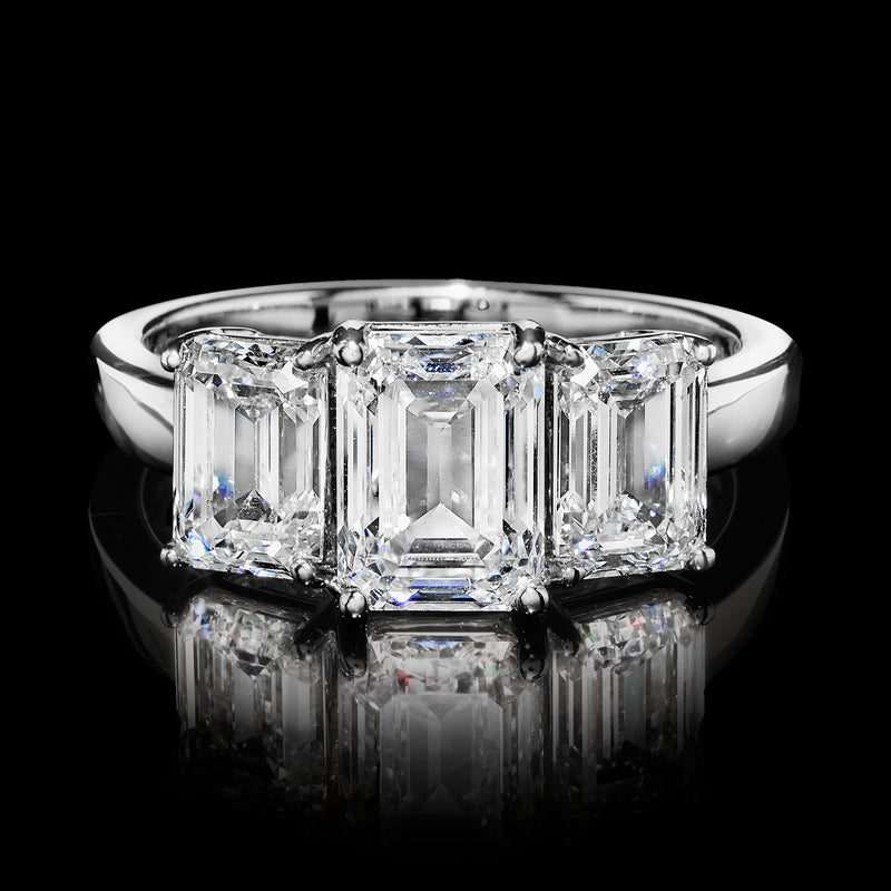 Three-stone emerald-cut diamond ring in 14kt white gold, close-up of center and side stones