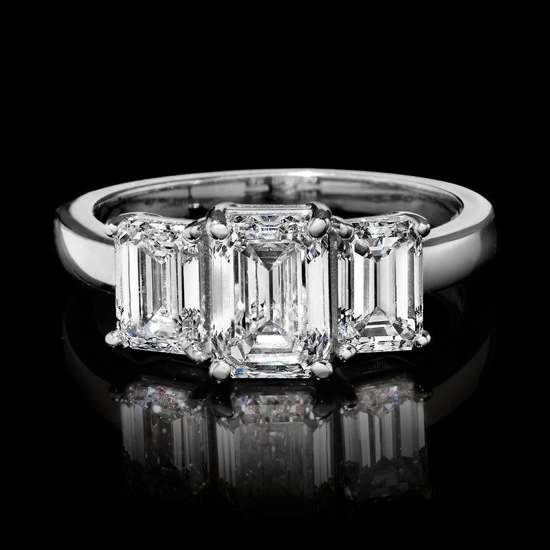 Three-stone emerald-cut diamond ring close-up on 14kt white gold band