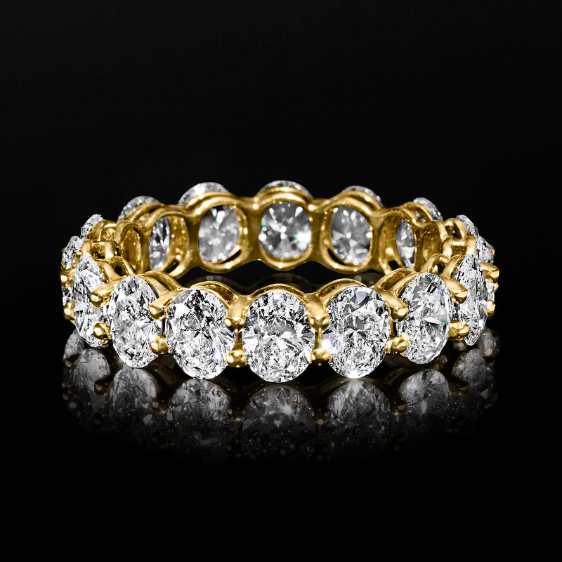 Oval diamond eternity band in yellow gold, bezel-set oval stones around the band