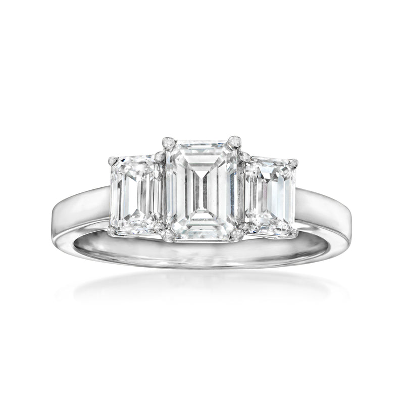 14kt white gold three-stone emerald-cut diamond ring, center emerald cut with side stones.
