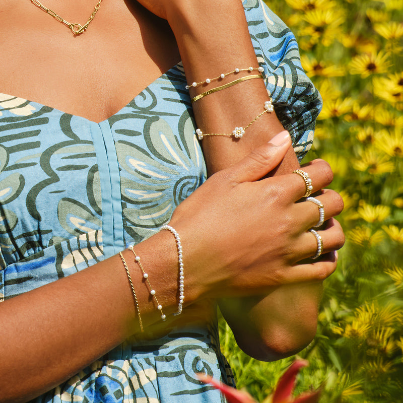 White pearl bead ring on hand with 14kt yellow gold beaded band