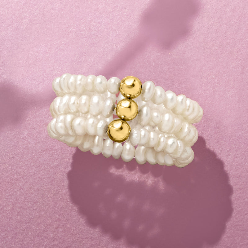 Cultured pearl stretch ring with three yellow gold dome accents, close-up