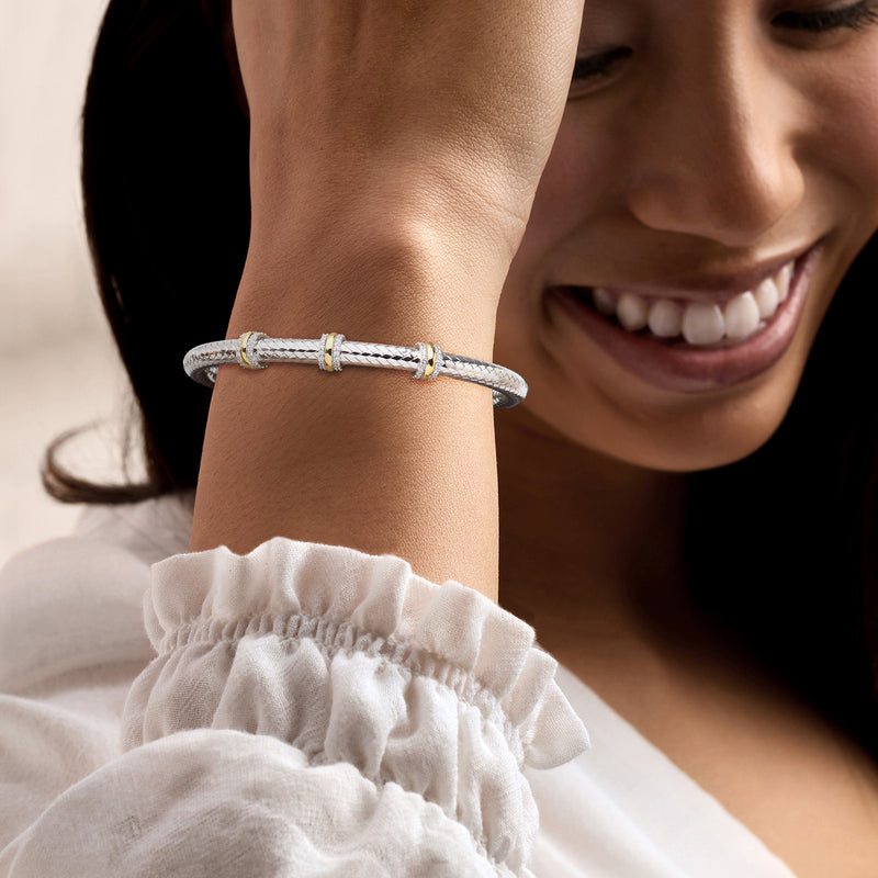 Sterling silver braided cuff bracelet with CZ stations and gold center bar on wrist