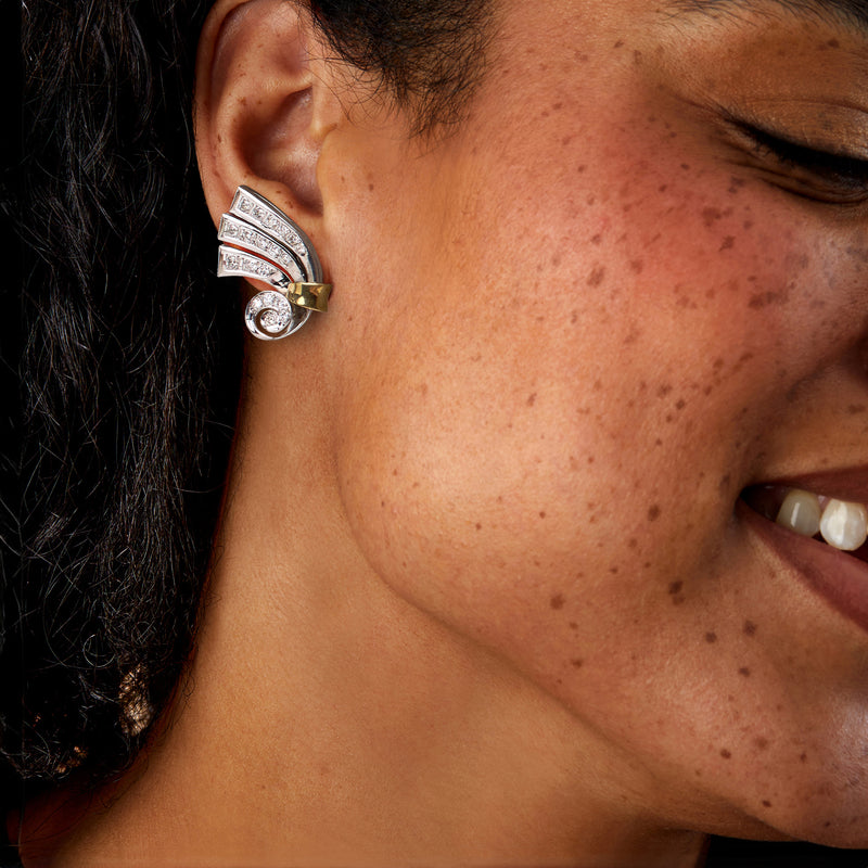 Two-tone gold diamond swirl post earrings on ear, side view
