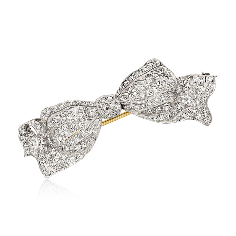 Platinum filigree diamond bow pin with intricate scrolling details
