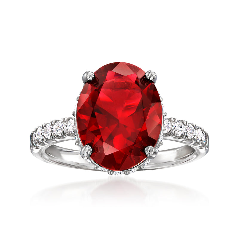 Sterling silver ring with oval red simulated gemstone center and small clear stone halo