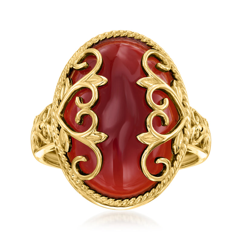 Gold-tone ring with red oval agate and heart scroll details on a shield setting