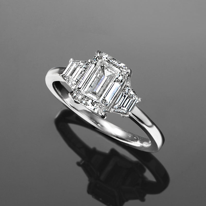 Diamond ring showing emerald-cut center and trapezoidal side stones in 14kt white gold