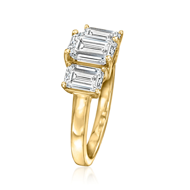 Three-stone emerald-cut diamond ring, yellow gold band with three framed emerald-cut stones