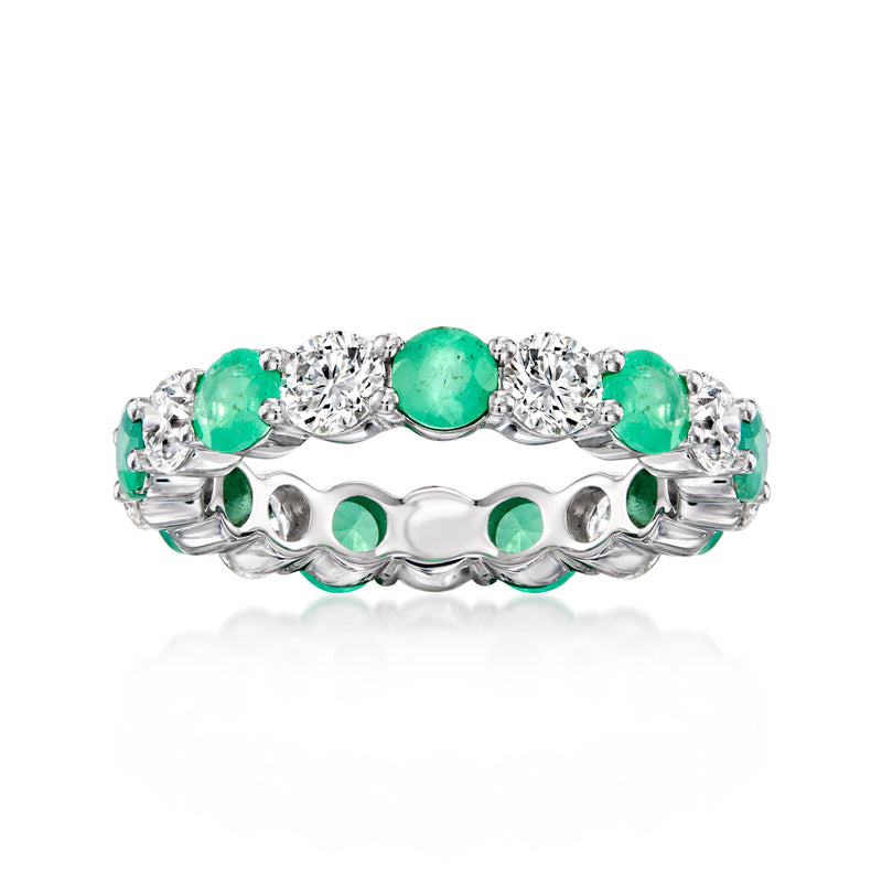White gold eternity band with green emerald and clear diamond accents, scalloped setting