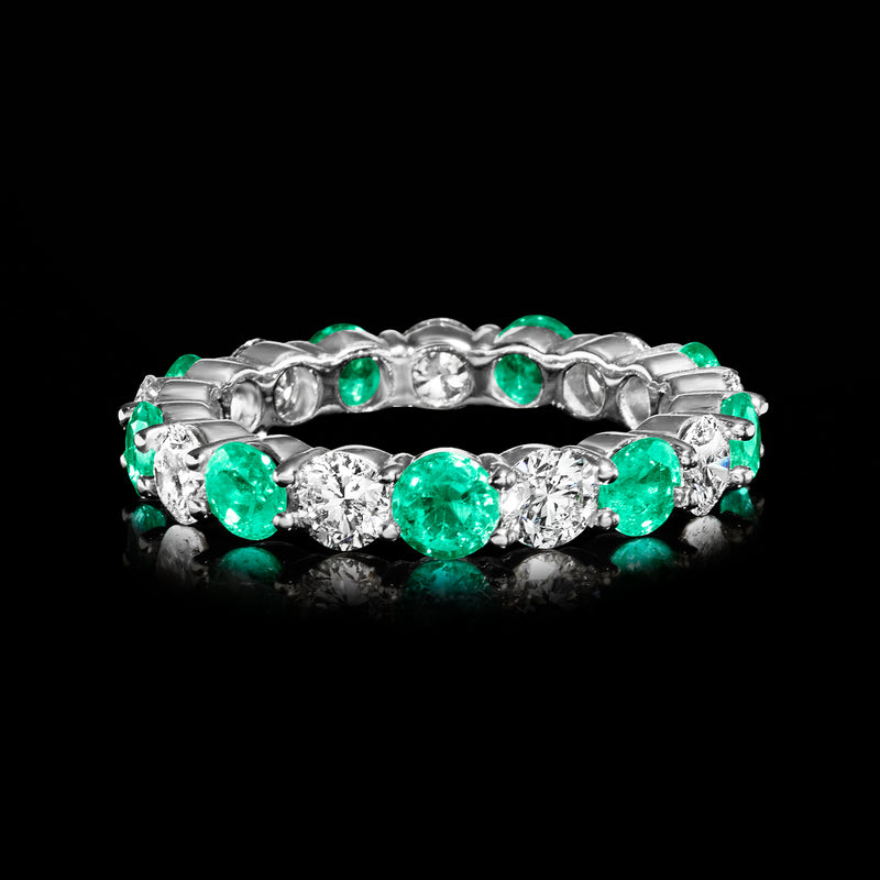 White gold eternity band with alternating green emeralds and clear round diamonds, profile