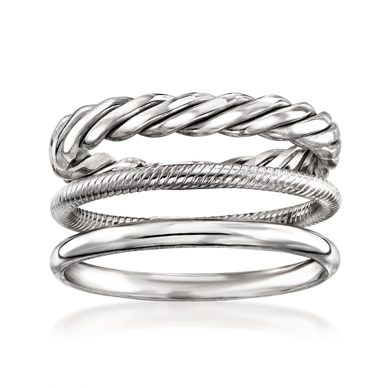 Three sterling silver rings with braided, rope, and smooth bands, stacked together
