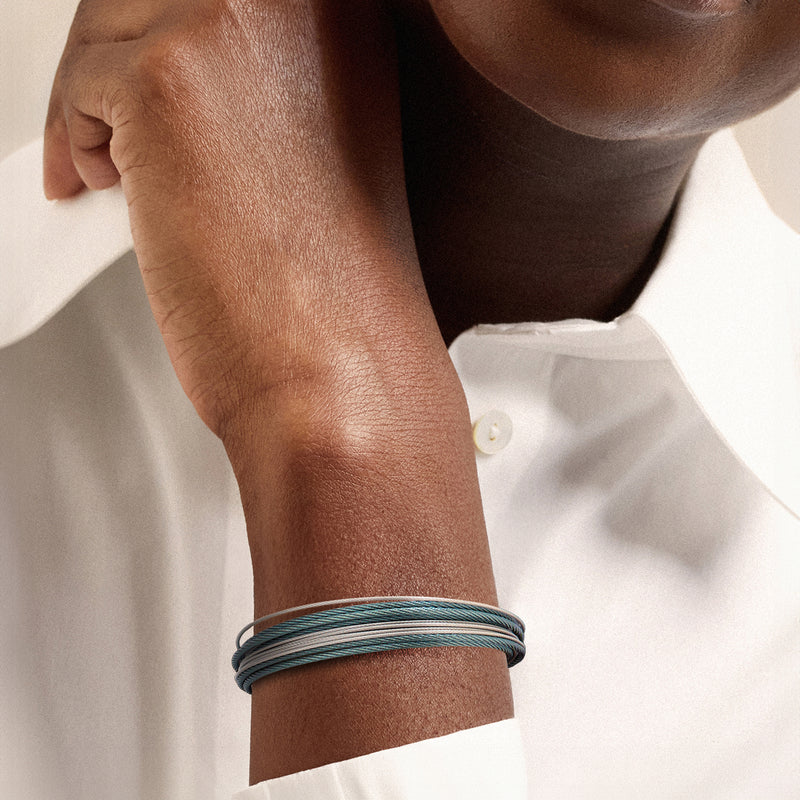 Multi-strand cable bracelet in blue and gray on wrist with silver clasp