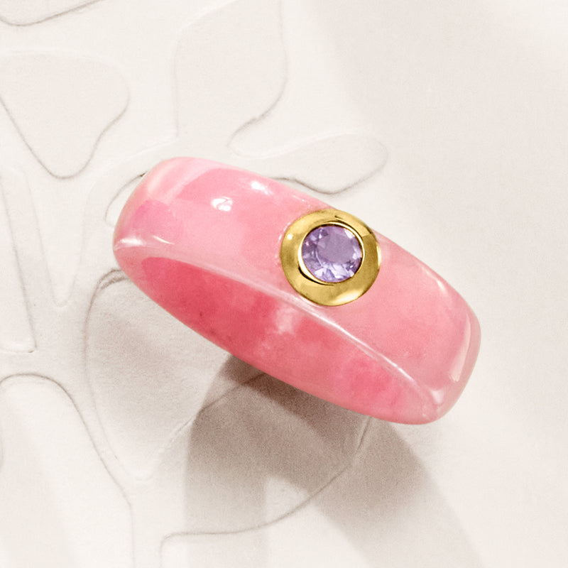 Pink jade band ring with small bezel holding round purple amethyst