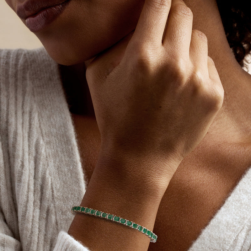 Sterling silver bracelet on wrist with green emerald stones and small diamond details