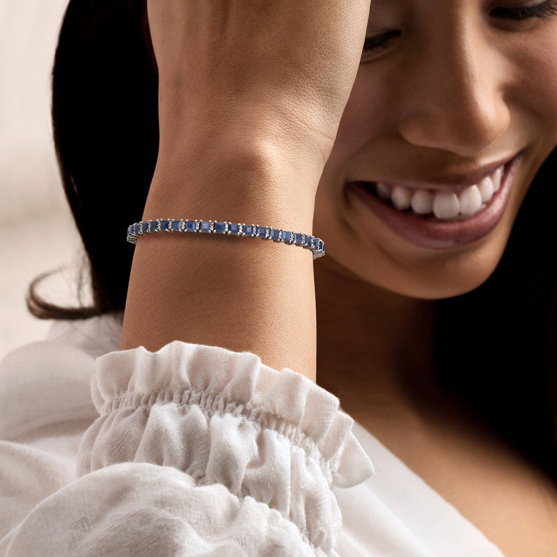 Sapphire tennis bracelet on wrist with square blue stones in sterling silver