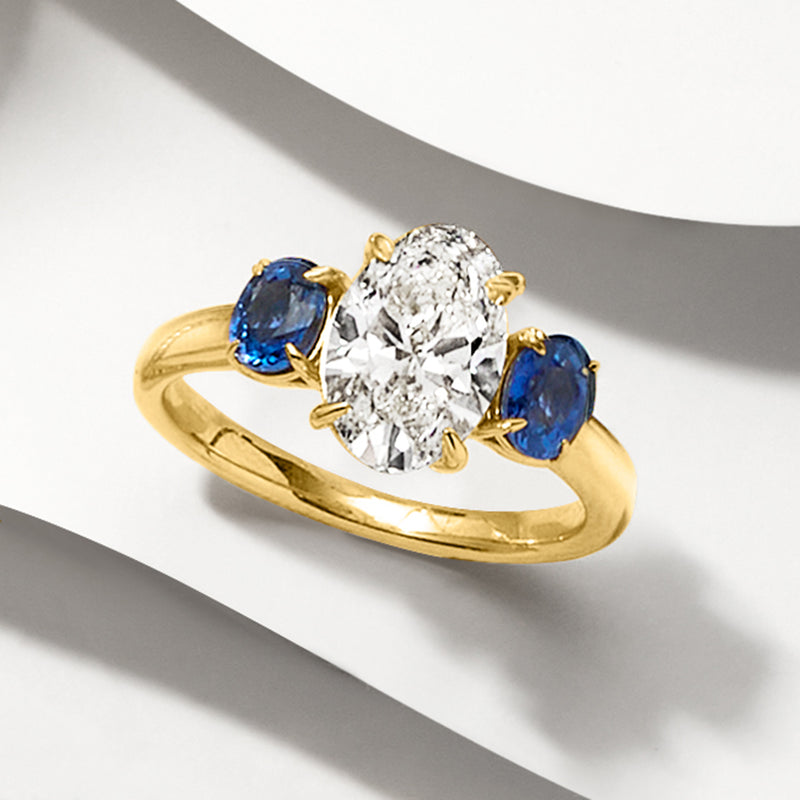 14kt yellow gold ring, round diamond with three oval blue sapphire prongs