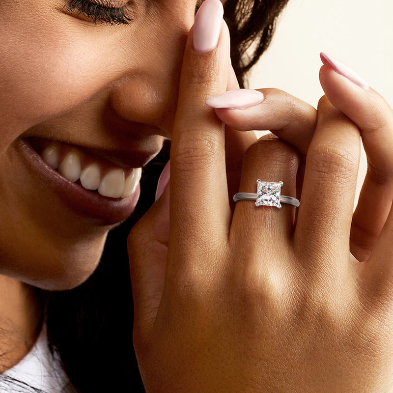 14kt white gold princess-cut diamond solitaire ring on finger, close-up