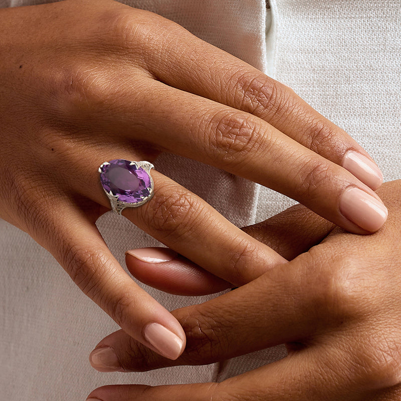 Vintage amethyst filigree ring on hand, oval purple gemstone in white gold setting