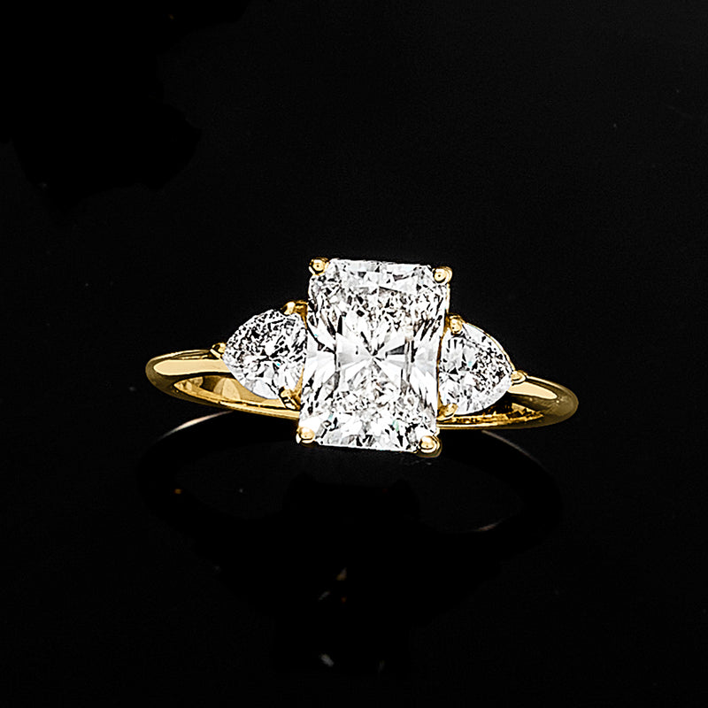Radiant-cut diamond ring in 14kt yellow gold with three clustered stones