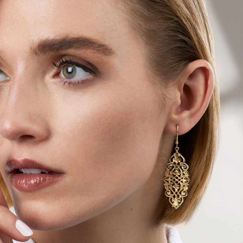 Gold over sterling filigree drop earrings on model’s ear, ornate teardrop
