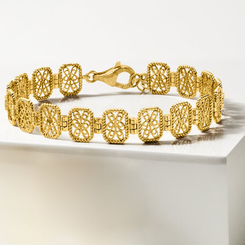 Gold filigree link bracelet with oval cutout panels and interlocking chain clasp