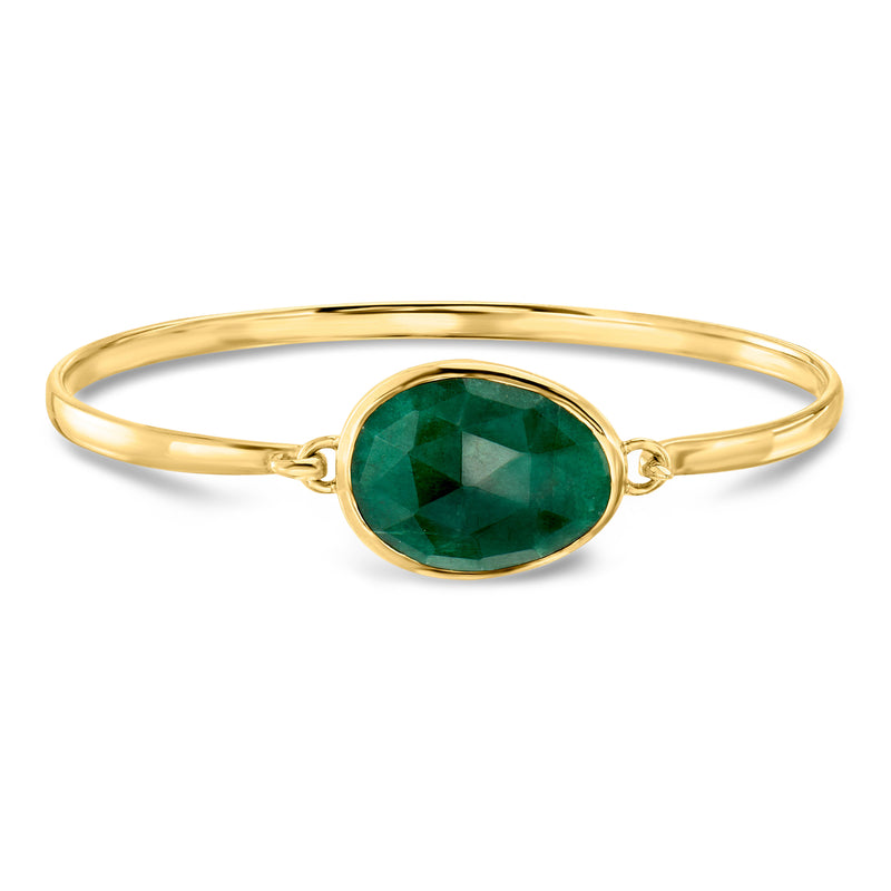Gold bangle bracelet with oval green gemstone and open oval halo setting