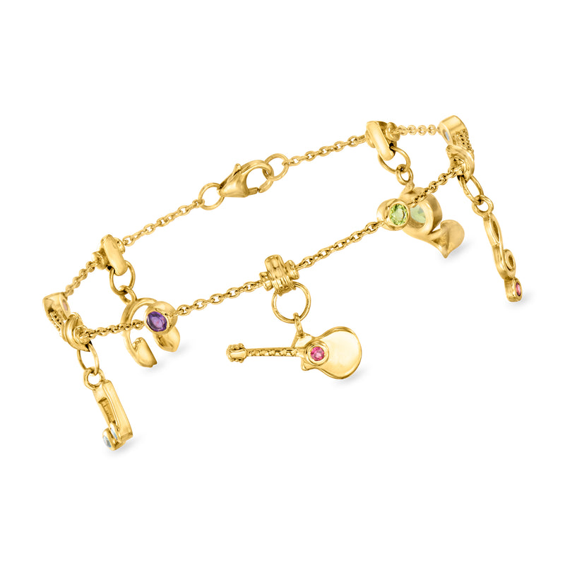 Gold-tone multi-charm bracelet with gemstone notes, key, and heart accents