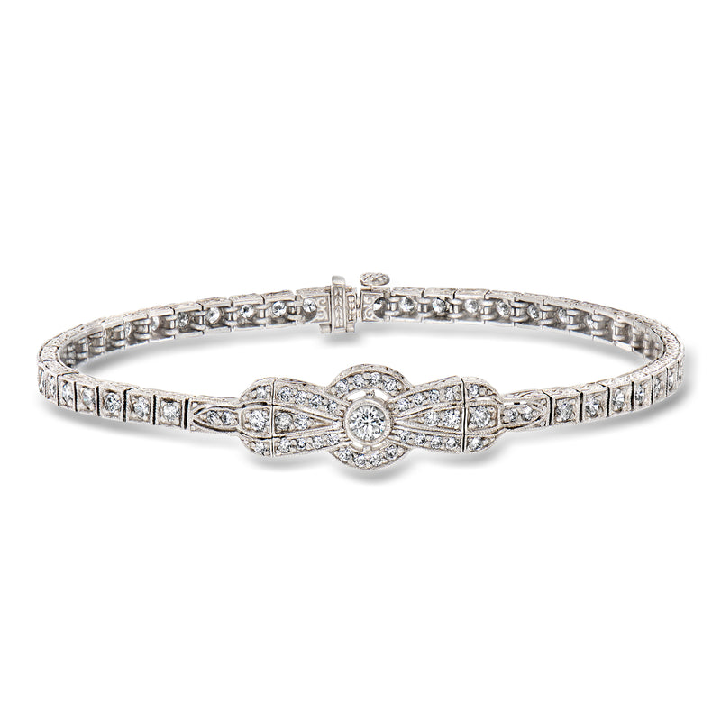 Platinum diamond bow bracelet with round center stone and pave links