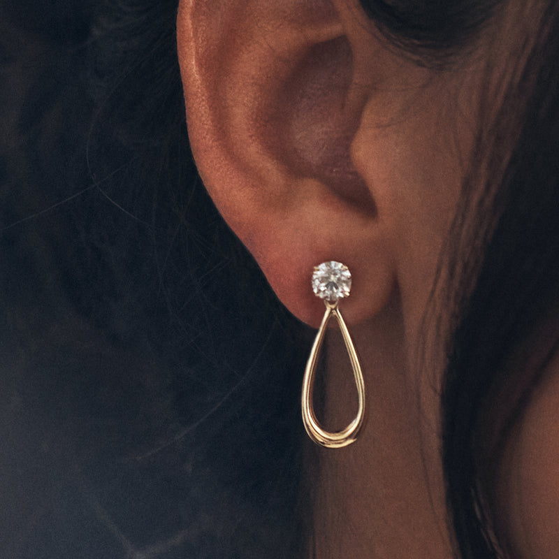 Close-up: 14kt yellow gold open teardrop earring jacket with round crystal stud