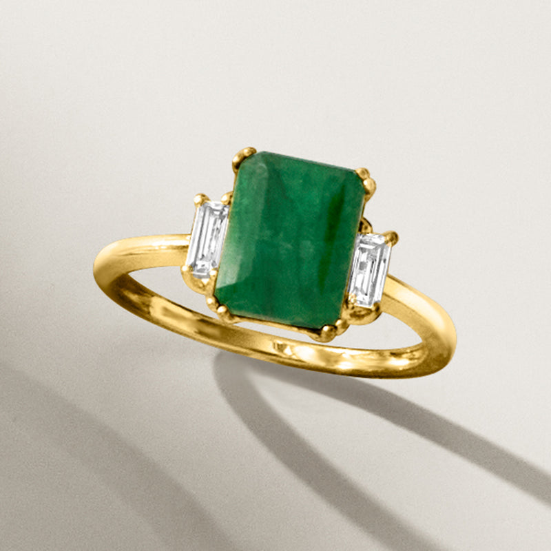 Gold ring featuring an emerald-green emerald-cut center stone with white baguette accents.