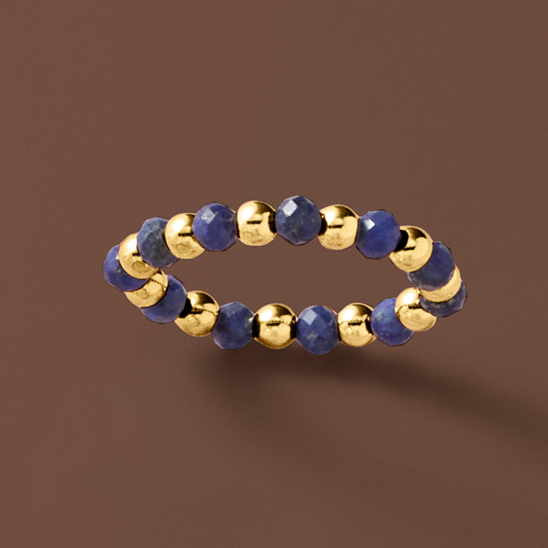 Dark blue lapis and 14kt yellow gold bead stretch ring, flat lay view
