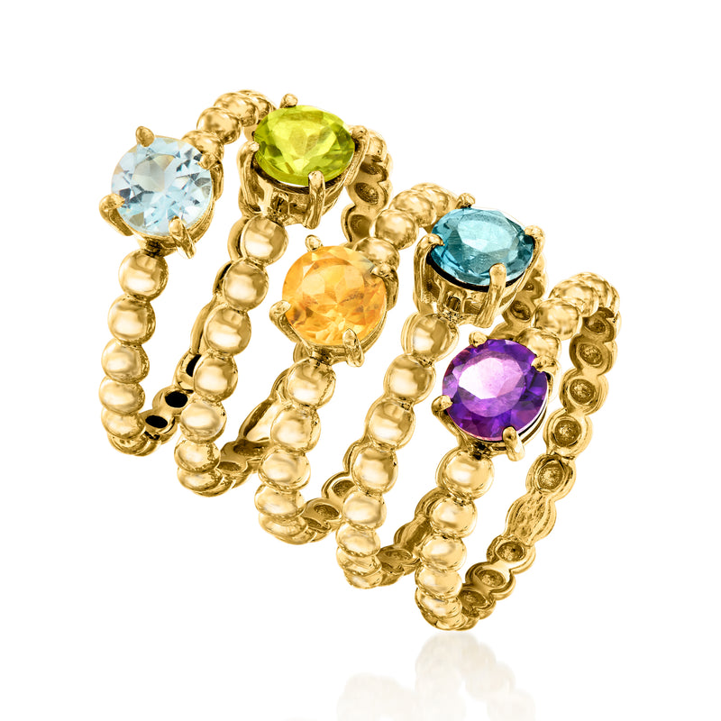 Five-ring jewelry set with green, light blue, teal, orange, and purple gemstones in gold-tone settings