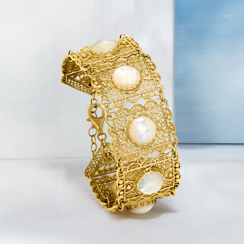 Gold filigree panel bracelet with three mother-of-pearl round insets, side view