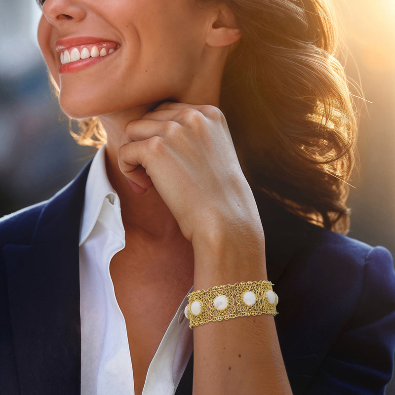 Gold filigree bracelet with three mother-of-pearl round insets on wrist