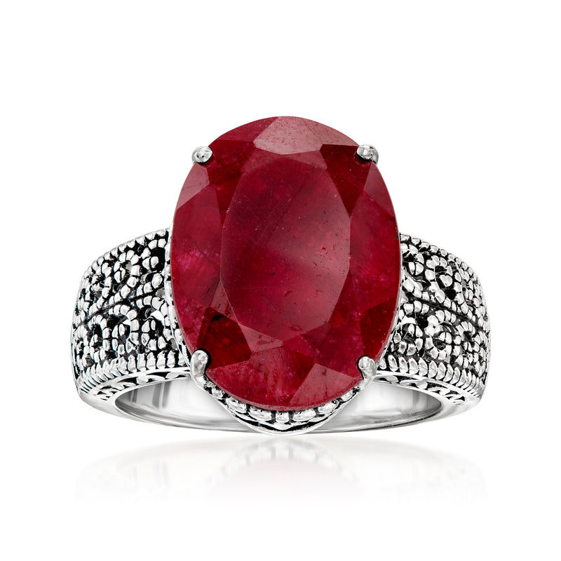 Sterling silver ring with large oval ruby-red gemstone and ornate side filigree