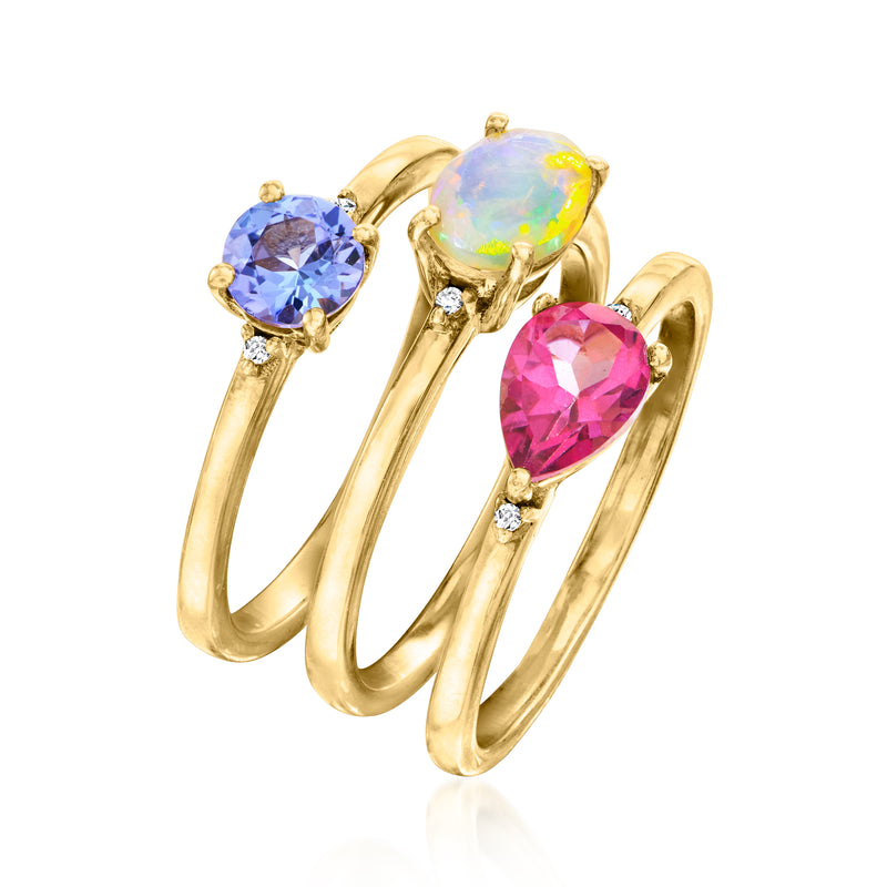 Gold-tone multi-ring set with blue, opal-like, and pink oval stones and small diamond accents