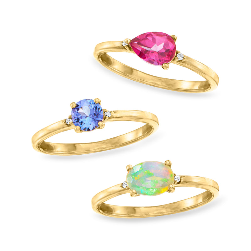 Gold-tone trio of rings with blue, pink, and opal-like oval gemstones and diamond details