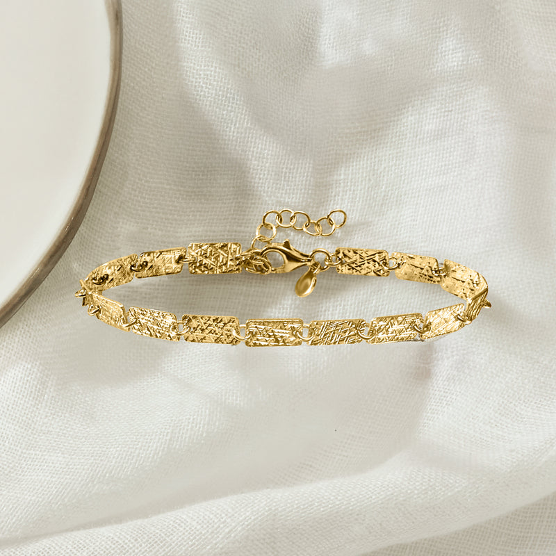 Gold-tone rectangular-link bracelet with toggle clasp, close-up on chain and links