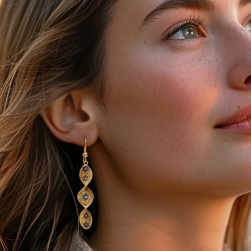 Gold earwire drop earrings with three-tier blue enamel oval floral motifs